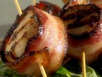 bacon wrapped around diver sea scallops with a toothpick speared through